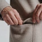 Mains decousant les poches cousues dun manteau