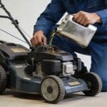 mecanicien verse huile moteur dans petite tondeuse