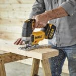 Ouvrier decoupant planche bois avec scie sauteuse Dewalt sans fil