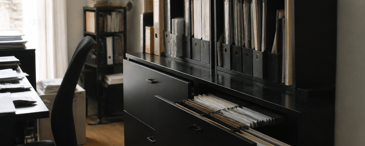Bureau organise avec classeurs verticaux et tiroirs ouverts