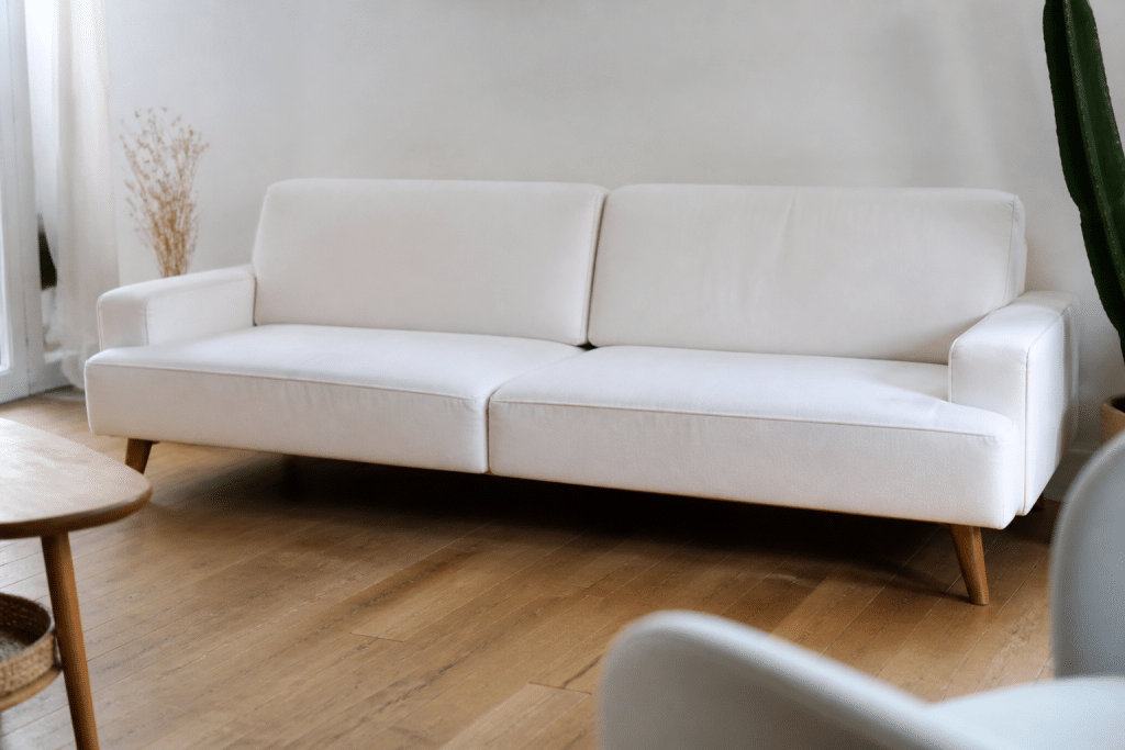 Canapé scandinave blanc avec pieds bois inclinés fins