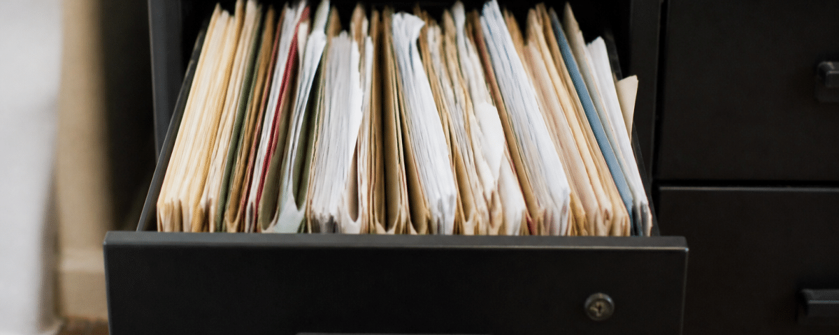 Dossiers papier empiles verticalement dans tiroir bureau ouvert
