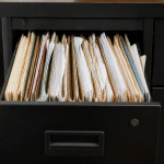 Dossiers papier empiles verticalement dans tiroir bureau ouvert