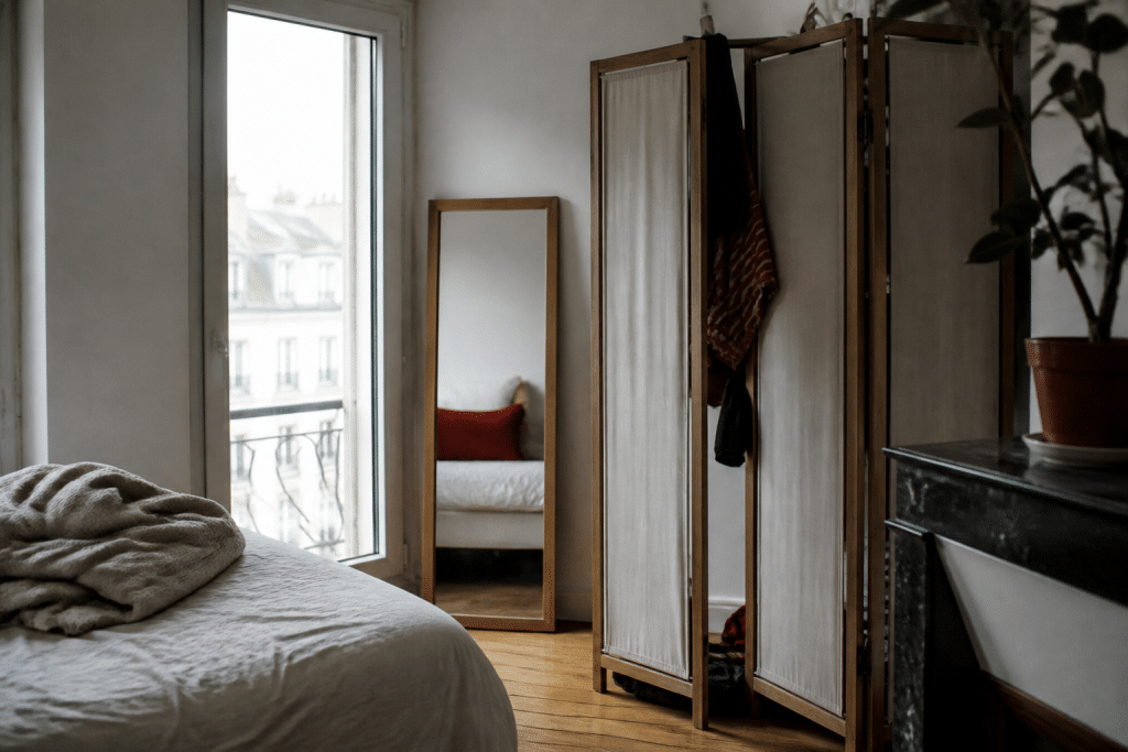 Petit appartement avec miroir face fenetre et paravent mobile