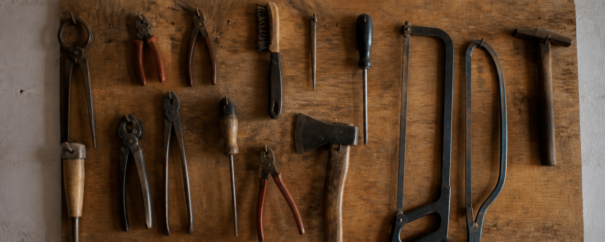 Outils suspendus sur panneau bois fixe au mur