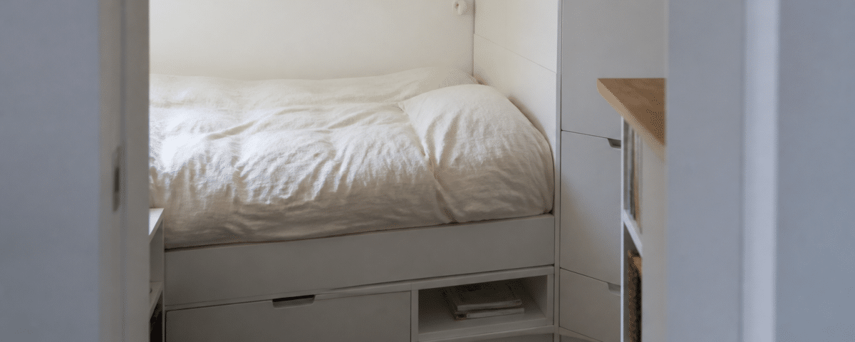 petit espace avec lit compact rangements integres murs blancs