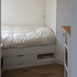 petit espace avec lit compact rangements integres murs blancs