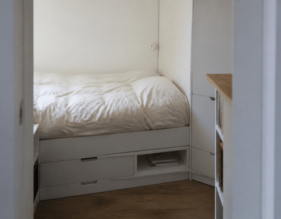 petit espace avec lit compact rangements integres murs blancs