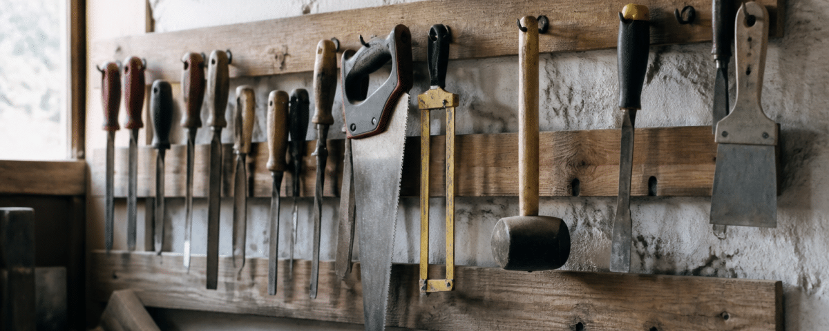Planche murale en bois horizontal fixee au mur avec outils suspendus