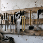 Planche murale en bois horizontal fixee au mur avec outils suspendus