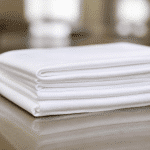 Mains pliant serviette blanche empilée sur surface plane