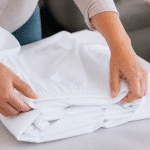 Mains pliant drap elastique blanc sur surface plane