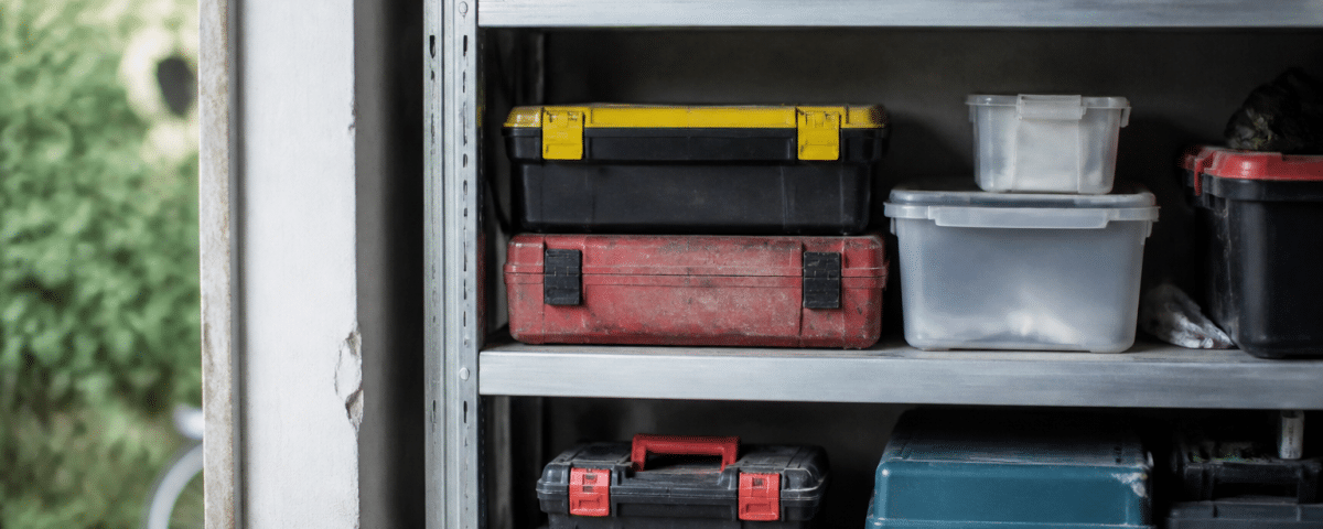 Outils et boites empiles sur etageres metalliques garage