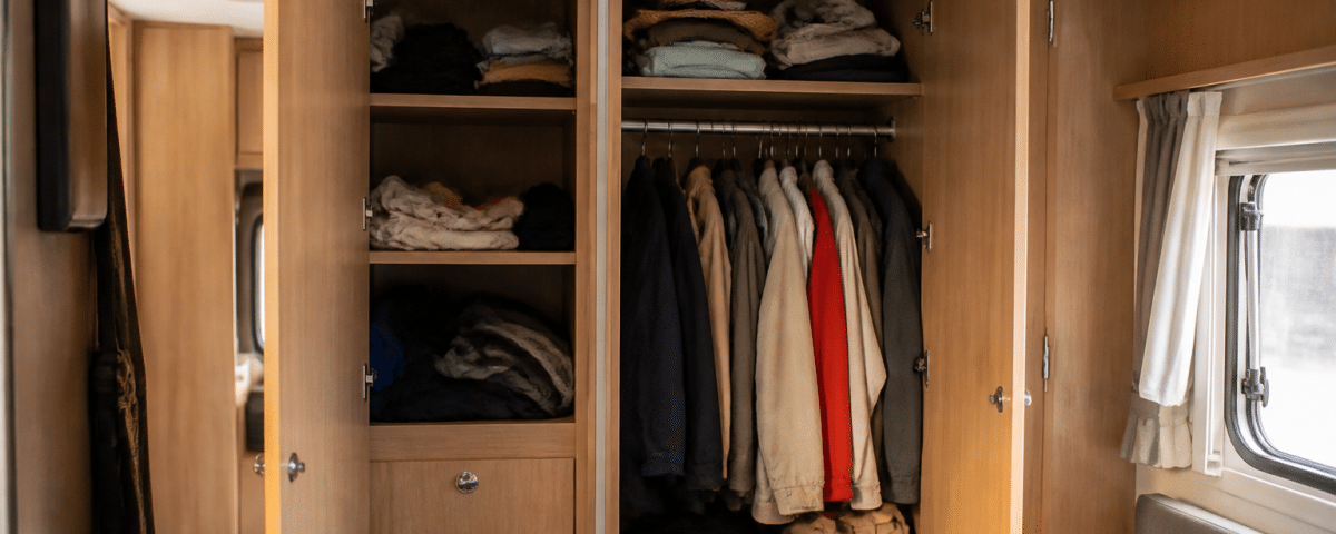 Armoires integrees avec portes ouvertes rangant vetements et accessoires camping-car
