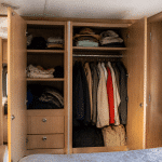 Armoires integrees avec portes ouvertes rangant vetements et accessoires camping-car