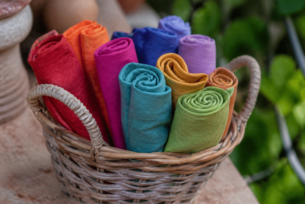 Serviettes roulees colorees dans panier osier naturel
