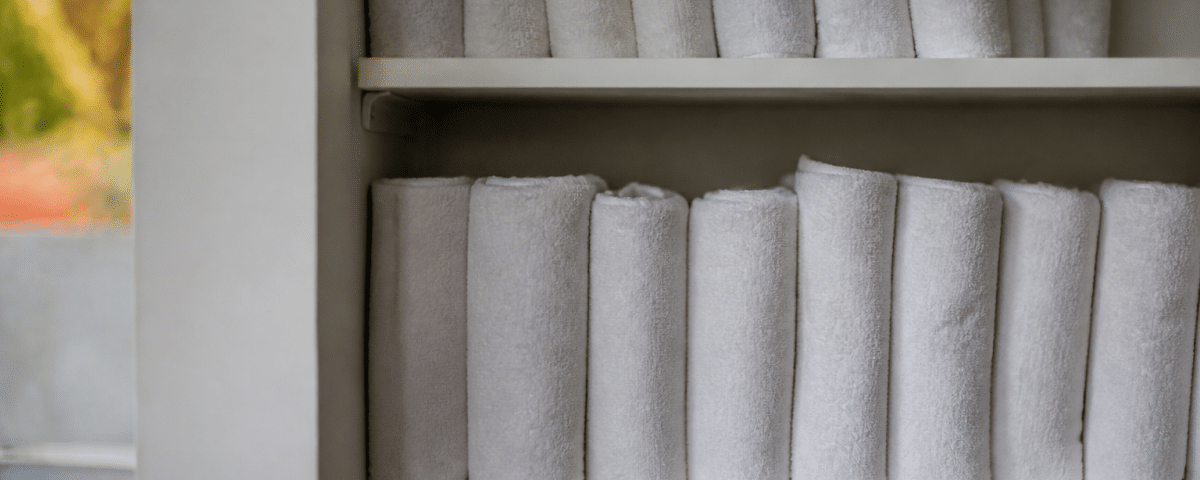 Serviettes roulees empilees verticalement sur etagere blanche
