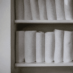 Serviettes roulees empilees verticalement sur etagere blanche