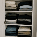 Vetements plies soigneusement ranges dans placard ouvert blanc