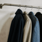Vetements suspendus sur une barre metallique fixee au mur
